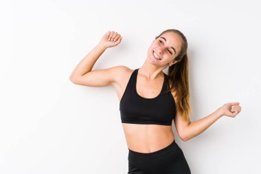 Beyaz arka planda dans eden ve eğlenen Kafkas fitness kadını..