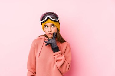 Young caucasian woman wearing a ski clothes isolated looking sideways with doubtful and skeptical expression.