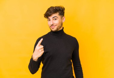 Sarı bir zemin üzerinde izole edilmiş genç bir Arap sizi parmağıyla işaret ediyor sanki davet ediliyormuş gibi..