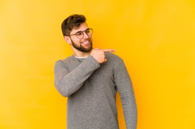 Sarı arka planda izole edilmiş genç beyaz adam gülümseyen, neşeli ve keyifli görünüyor..