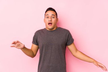 Pembe arka planda poz veren yog latin adam yakın bir tehlikeden dolayı şoka girdi.