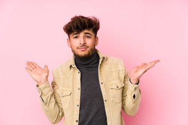 Arka planda poz veren genç bir Arap sorgulama sırasında kuşkuyla omuz silkiyor..