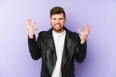 Mor arka planda izole edilmiş genç adam öfkeyle bağırıyor.