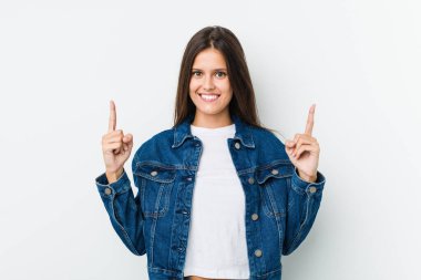 Genç ve tatlı bir kadın iki elini de havaya kaldırarak boş bir alan gösteriyor..