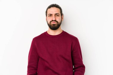 Beyaz arka planda izole edilmiş uzun saçlı genç adamın yanakları şişer, yorgun bir ifadesi vardır. Yüz ifadesi kavramı.