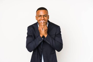 Genç iş adamı beyaz arka planda izole edilmiş bir şekilde bir şeye gülüyor, ağızlarını elleriyle kapatıyor..