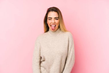 Orta yaşlı bir kadın soyutlanmış arka planda komik ve arkadaş canlısı bir dil uzatıyor..