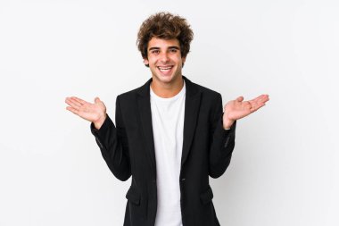 Beyaz bir geçmişi olan, beyaz tenli genç beyaz bir iş adamı kollarıyla ölçek yapar, mutlu ve kendinden emin hisseder..