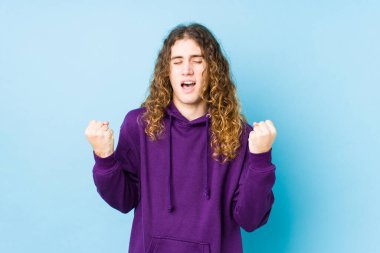 Uzun saçlı adam yalnız poz veriyor gamsız ve heyecanlı. Zafer konsepti.