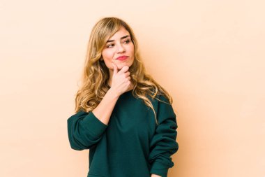 Şüpheli ve şüpheci bir ifadeyle yan bakan genç sarışın, beyaz kadın..