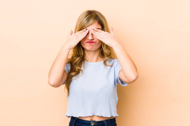 Sarışın, beyaz bir kadın elleriyle gözlerini kapatmaktan korkuyor..