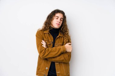 Uzun saçlı adam yalıtılmış sarılmalar sergiliyor, kaygısız ve mutlu gülümsüyor..