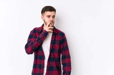 Beyaz arka planda yalnız poz veren genç beyaz bir adam gizli bir sıcak fren haberi veriyor ve yana bakıyor.