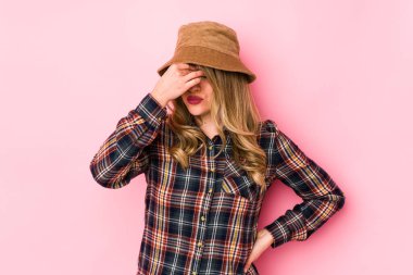 Kafkasyalı şapkalı genç bir kadın izole edilmiş, başı ağrıyor, yüzüne dokunuyor..