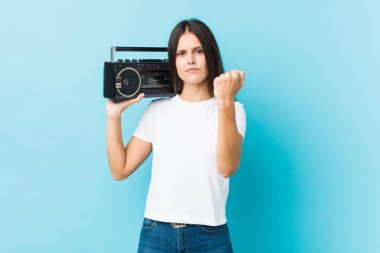 Guetto tabancasını tutan genç beyaz kadın kameraya yumruğunu gösteriyor, agresif yüz ifadesi..