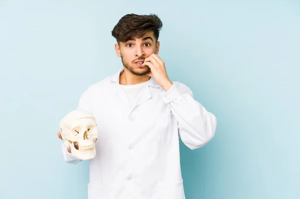 Joven Médico Árabe Sosteniendo Cráneo Mordiendo Las Uñas Nervioso Muy —  Fotos de Stock