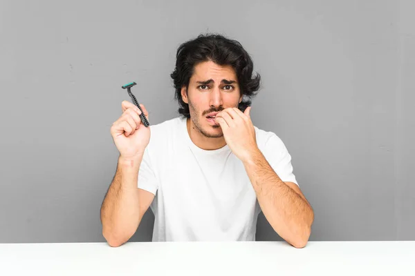 Jongeman Met Een Scheermes Bijtende Nagels Nerveus Zeer Angstig — Stockfoto