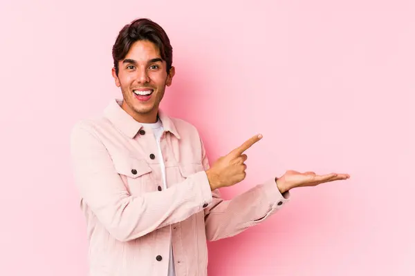 Jovem Caucasiano Posando Fundo Rosa Isolado Animado Segurando Espaço Cópia — Fotografia de Stock