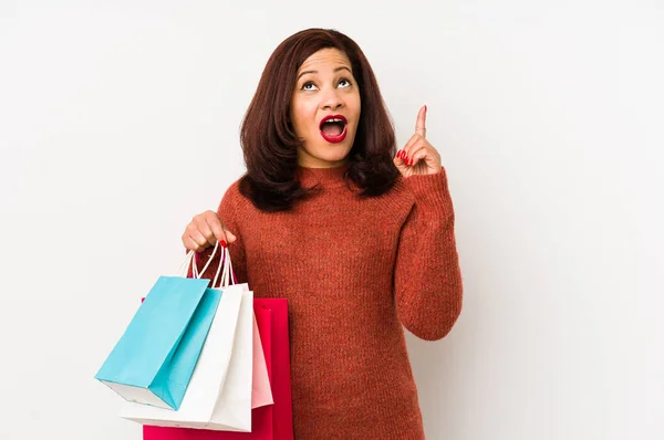 Medelålders Latinamerikansk Kvinna Håller Shoppingpåse Isolerad Pekar Upp Och Med — Stockfoto