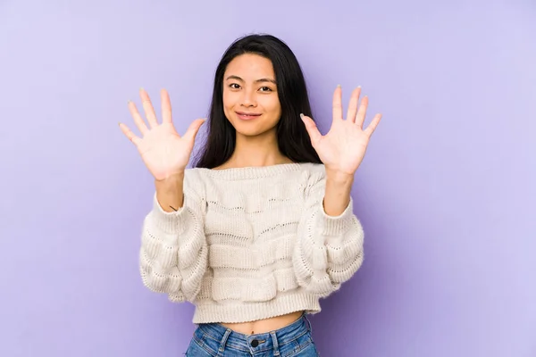若いです中国の女性は手で10番を示す紫色の背景に隔離されました — ストック写真