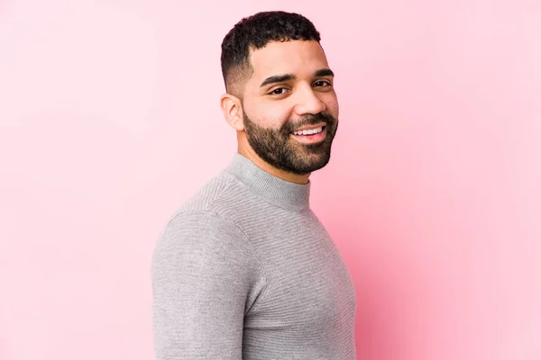 Joven Hombre Latino Sobre Fondo Rosa Aislado Mira Lado Sonriente —  Fotos de Stock