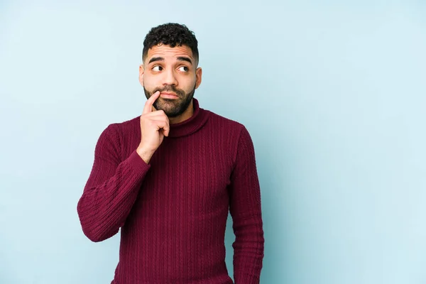 Young mixed race arabic man isolated looking sideways with doubtful and skeptical expression.