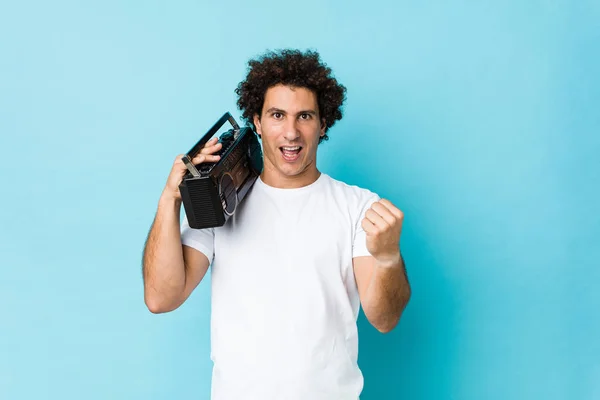 Young Caucasian Curly Man Holding Guetto Blaster Cheering Carefree Excited — Stock Photo, Image