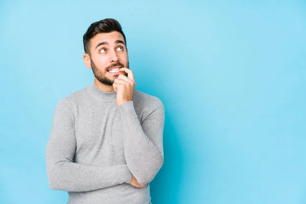 Joven Hombre Caucásico Sobre Fondo Azul Aislado Mirando Hacia Los —  Fotos de Stock