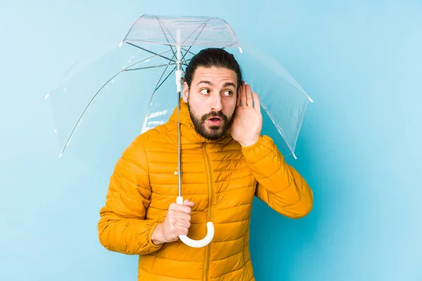 若い男が長い髪を着て傘を持っているゴシップを聞こうとして隔離された — ストック写真