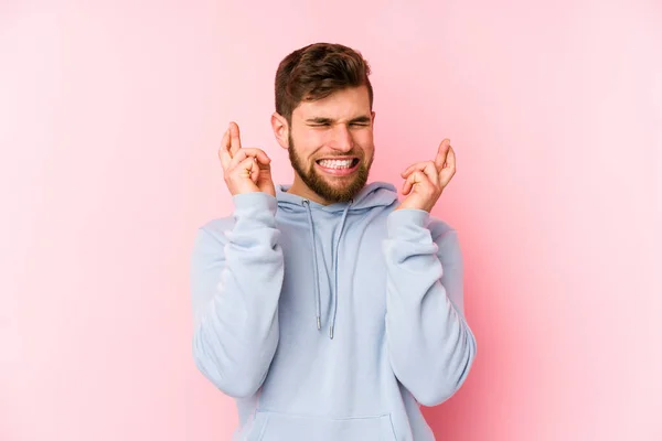 Joven Hombre Caucásico Aislado Sobre Fondo Rosa Cruzando Dedos Para — Foto de Stock