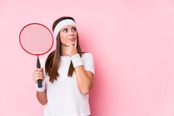 Ung Kaukasisk Kvinna Spelar Badminton Isolerad Tittar Sidled Med Tveksamma — Stockfoto