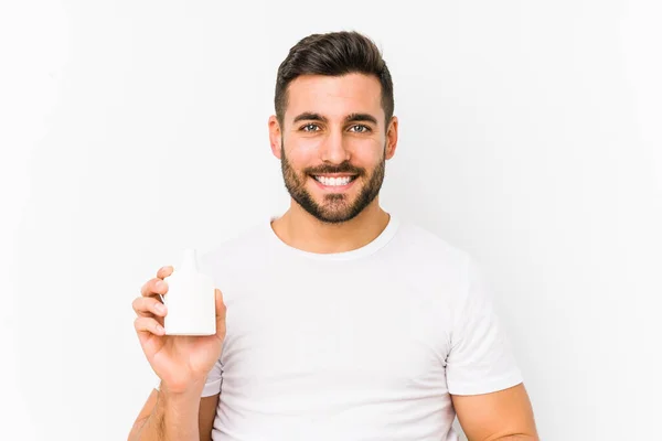 Joven Hombre Caucásico Sosteniendo Una Botella Vitaminas Aislado Sonriendo Confiado —  Fotos de Stock