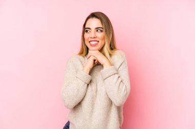 Soyutlanmış geçmişi olan orta yaşlı bir kadın ellerini çenesinin altında tutuyor ve mutlu bir şekilde yan tarafa bakıyor..