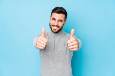 Mavi bir geçmişi olan genç beyaz bir adam. Başparmağıyla izole edilmiş. Bir konuda tezahürat yapıyor, destek ve saygı duyuyor..