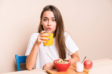 Genç beyaz kadın kahvaltı yapıyor.