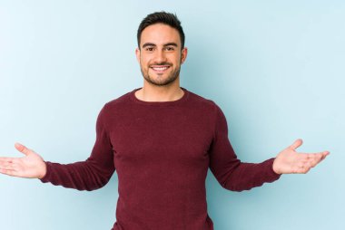 Mavi arka planda izole edilmiş beyaz bir genç hoş bir yüz ifadesi sergiliyor..