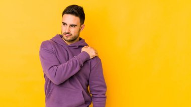 Sarı fırında yalıtılmış genç beyaz bir adam omuz ağrısı çekiyor..