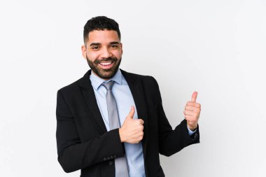 Beyaz bir geçmişi olan genç Latin iş kadını iki parmağını da kaldırıyor, gülümsüyor ve kendinden emin..