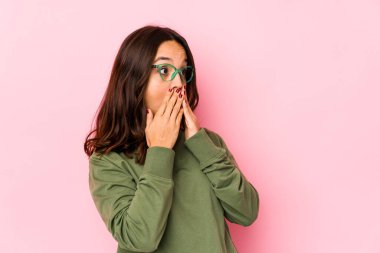 Latin kökenli genç bir kadın bir şeylere gülüyor, elleriyle ağzını kapatıyor..