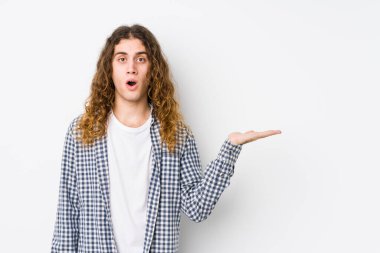 Genç, uzun saçlı, yalnız poz veren adam, avuç içi fotokopi alanı tutmaktan etkilenmiş..