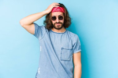 Genç, uzun saçlı, festival hippisi gibi giyinmiş. Şok olmuş görünüyor..