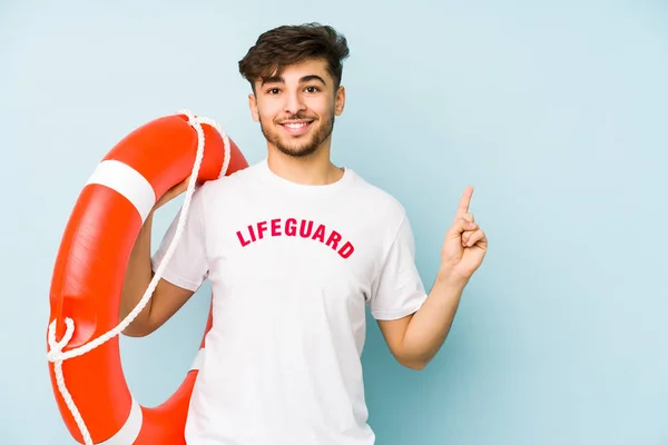 Joven Salvavidas Árabe Aislado Sonriendo Señalando Lado Mostrando Algo Espacio — Foto de Stock