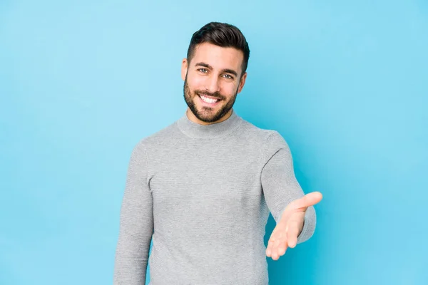 Jonge Blanke Man Tegen Een Blauwe Achtergrond Geïsoleerde Stretching Hand — Stockfoto