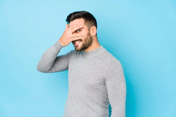 Young Caucasian Man Blue Background Isolated Blink Camera Fingers Embarrassed — Stock Photo, Image