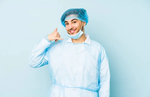 Молодий Арабський Хірург Ізольований Синьому Фоні Показуючи Жест Мобільного Телефону — стокове фото