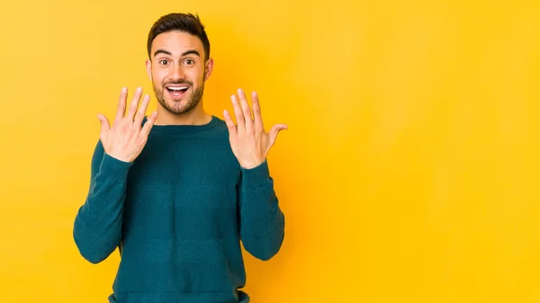 Jonge Blanke Man Geïsoleerd Gele Bakgrond Met Nummer Tien Met — Stockfoto