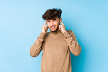 Genç Arap adam elleriyle kulaklarını kapatıyor..