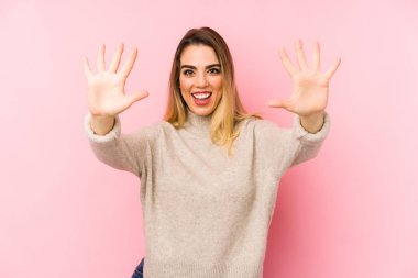 Orta yaşlı bir kadın izole edilmiş arka planda 10 numarayı elleriyle gösteriyor..