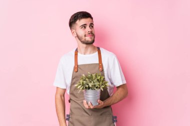 Kafkasyalı genç bahçıvan elinde bir bitki tutuyor. Hedeflerine ve amaçlarına ulaşma hayali kuruyor.