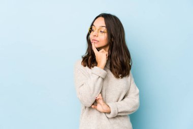 Latin kökenli genç bir kadın şüpheli ve şüpheci bir ifadeyle yanlamasına bakıyor..